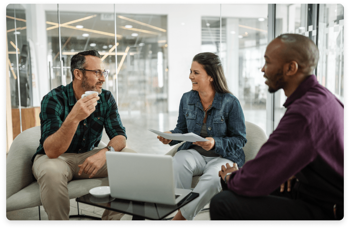 
                  Three professionals in a casual meeting space with modern office interiors,
                  featuring a man holding a coffee cup, a woman with documents, and another man engaging in a discussion,
                  representing a collaborative bookkeeping team for technology firms.
                