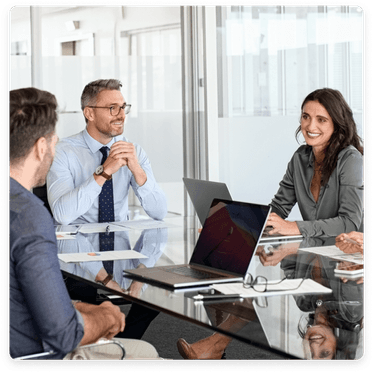 Clickable image: A professional meeting with marketing strategists around a glass table in an office. Learn more about accounting services for marketing agencies.