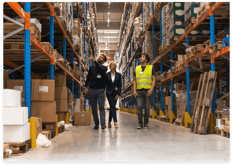 
                  Two business professionals and a warehouse worker in a safety vest walking through an eCommerce warehouse,
                  discussing inventory, symbolizing the complex operational and accounting challenges addressed by expert
                  bookkeeping services.
                