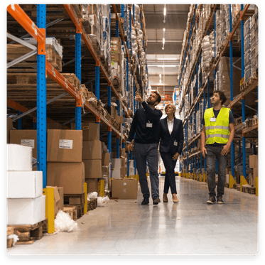 Clickable image: Warehouse scene with three individuals managing ecommerce logistics. Discover accounting solutions for ecommerce businesses.